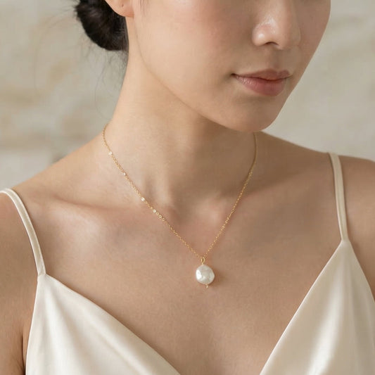 Woman wearing a pearl necklace against a neutral background