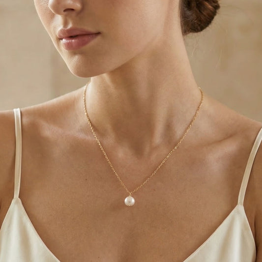 Woman wearing a pearl necklace against a neutral background